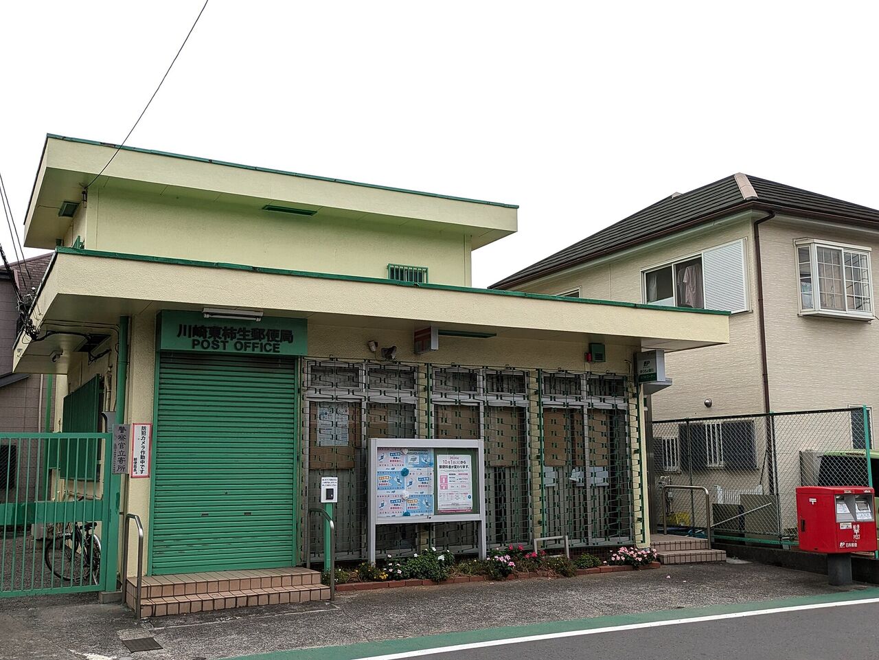 王禅寺東にある小さな郵便局の建物と、その右どなりの2階建ての家
