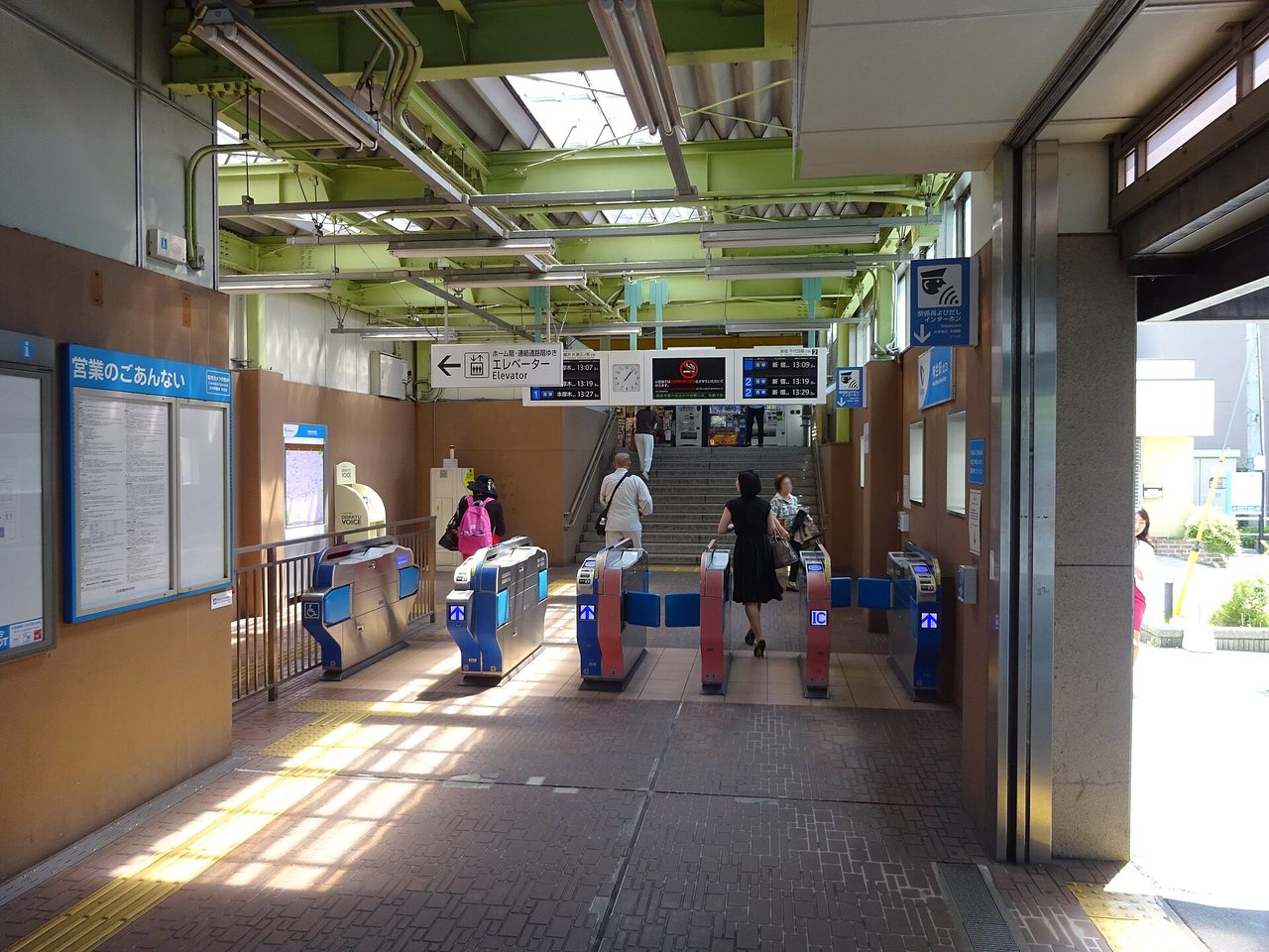 柿生駅の北口の改札。青と赤の自動改札機が並び、奥にホームへの階段が見える（2017年撮影）
