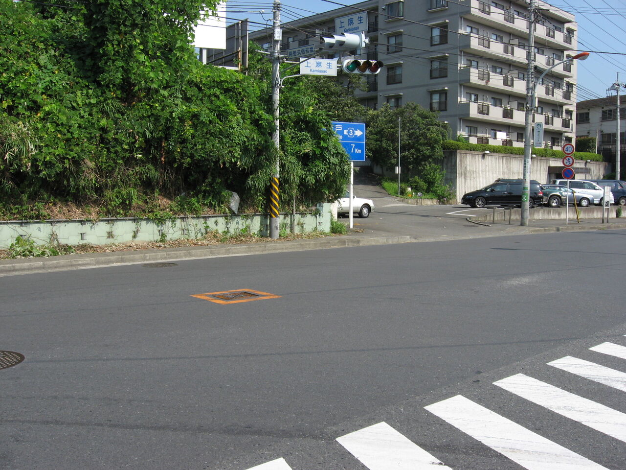 上麻生交差点。信号の上に「上麻生」の地名の看板、右に番号「3」の道路の案内標識がある。手前に横断歩道