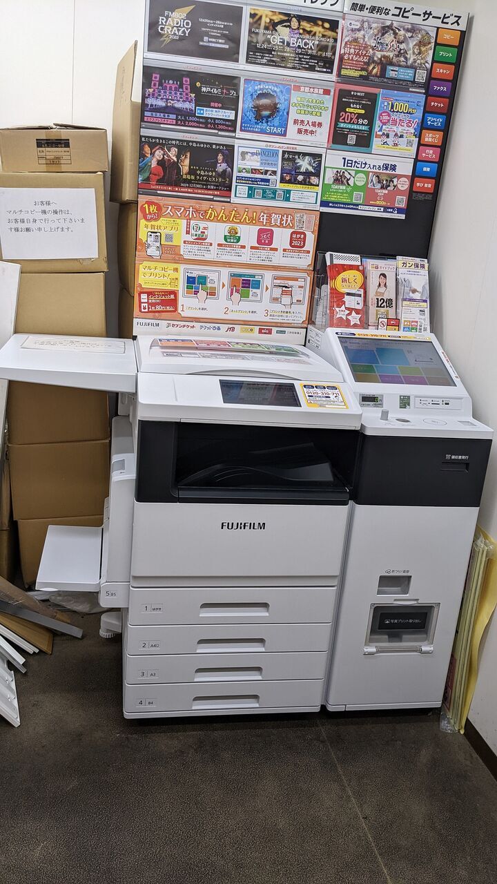 コンビニの店内に置かれた、白いマルチコピー機。となりに別の端末がある