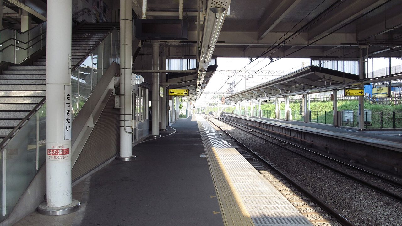五月台駅のホーム。屋根の下に階段とホームが続き、柱に「さつきだい」の駅名の表示がある