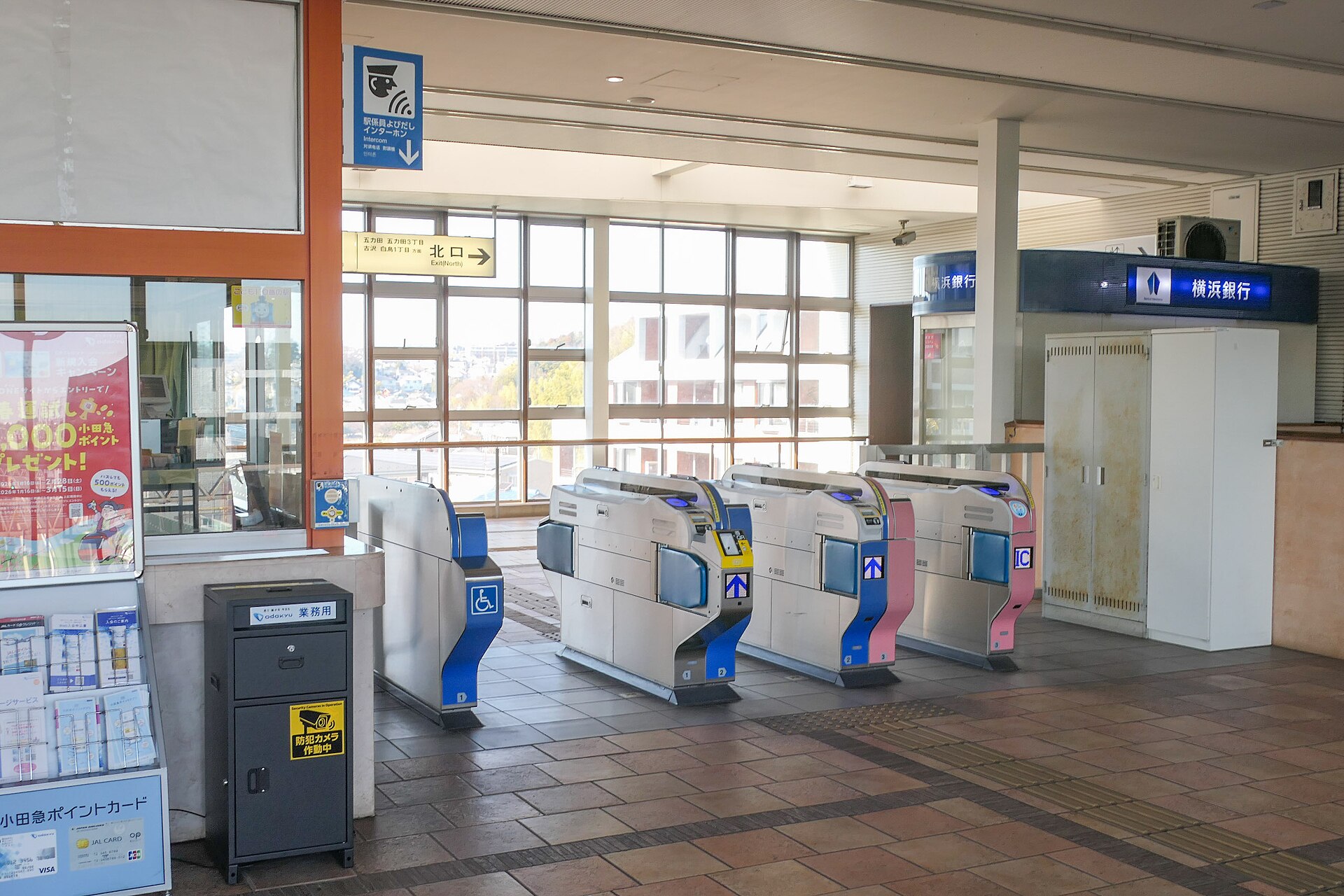 五月台駅の改札。右側にICカードの読み取り部のある改札機が並び、奥の窓に、北口の方向を示す案内が見える