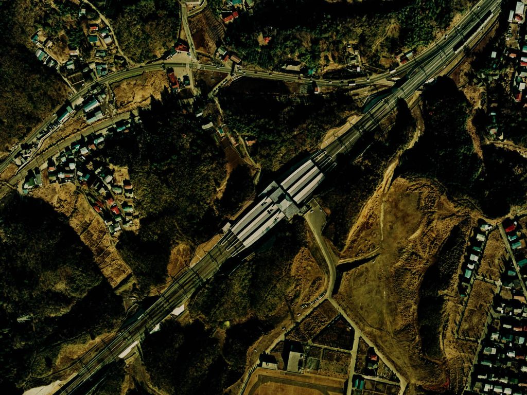1974年ごろの新百合ヶ丘駅の上空写真。駅のまわりは林と造成地で、家は写真の端にまとまっている